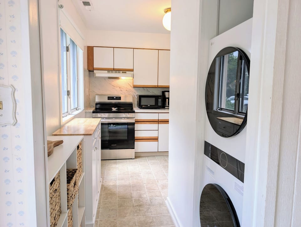 718D Treetop Lane - Stacked Washer and Dryer - Strategically located in the hallway near the kitchen, a high-efficiency stacked washer and dryer unit maximizes the use of space. This modern laundry setup is conveniently positioned to handle household tasks without intruding on the main living areas.