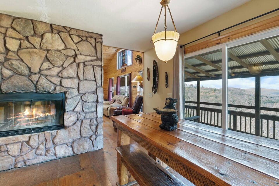 This handcrafted dining table has gorgeous views overlooking the river and cozy warmth of the fireplace. 