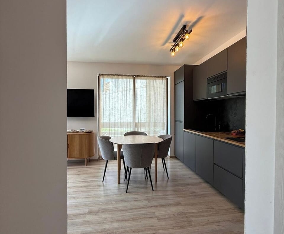 Seamless connection between kitchen, dining, and living areas creates a warm, inviting space for socializing, watching TV, or enjoying a quiet evening with a mountain backdrop.