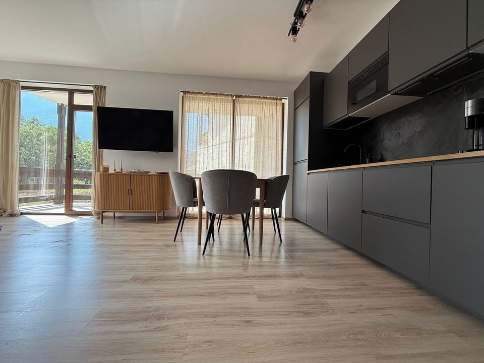 A fully equipped kitchen with sleek finishes, a large dining table for four, induction cooktop, Nespresso machine, kettle, and all the essentials to enjoy coffee and meals at home.

