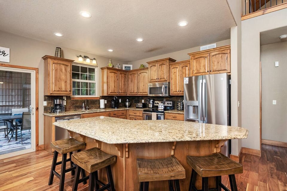 Main level kitchen with island seating and stainless steel appliances and kitchen aid mixer