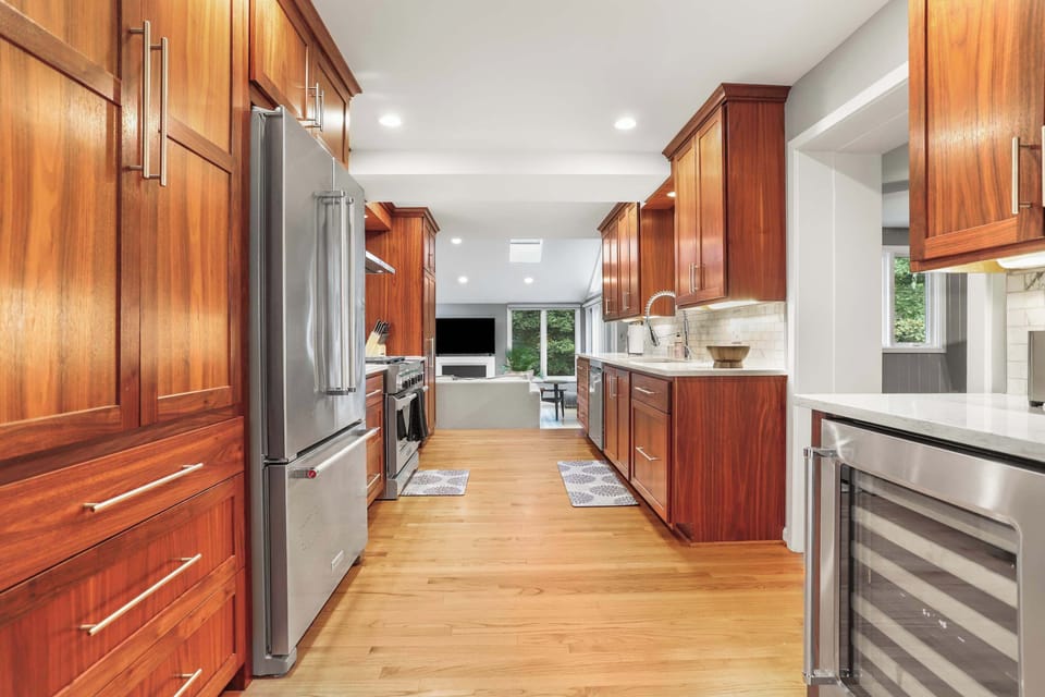 Full kitchen with a view of middle level living room and a doorway to the right leading to the home gym area.