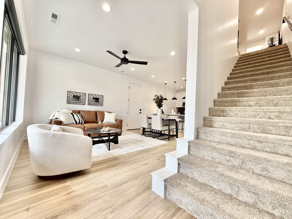 The living room offers comfortable furnishings and an abundance of natural light. Head upstairs to find an additional gathering space, 2 more bedrooms and bathrooms, and a second laundry room.