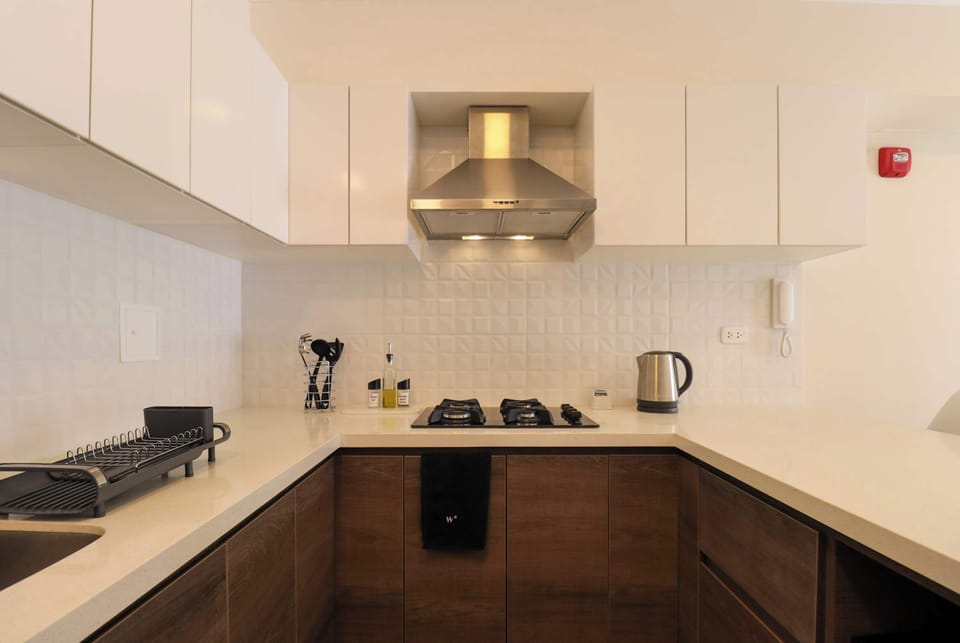 Angle view of the kitchen with upper white cabinets and brown lower cabinets.