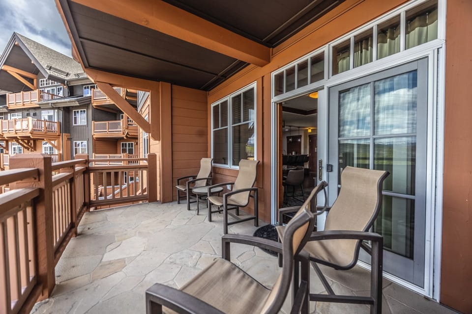 Covered Flagstone Balcony with 4 Chairs & Living Room Access
