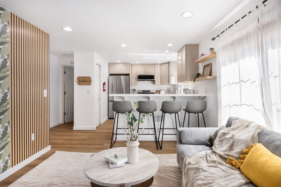 Modern Minimalist Oasis---An open-plan space blending living, dining, and kitchen zones with clean lines and organic touches.