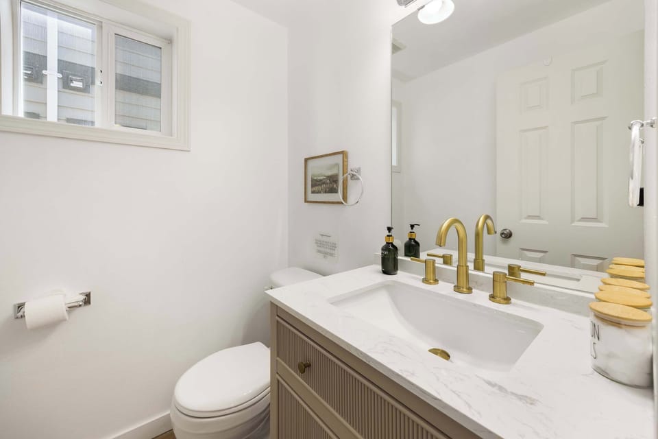 Stylish half bath – Features a marble vanity with gold fixtures for a touch of luxury.
