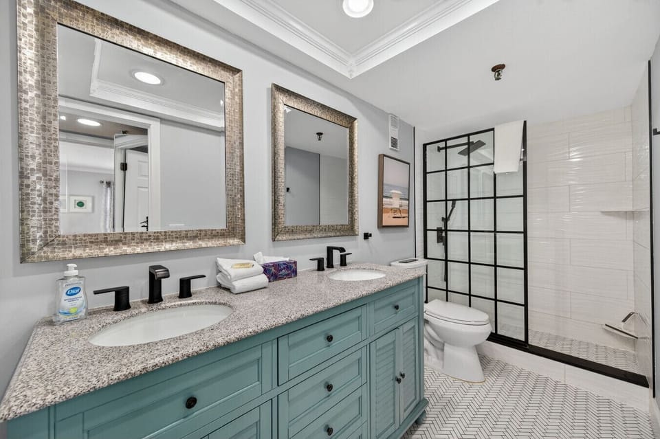 Bathroom w/ a bright vanity, modern finishes & a spacious shower.