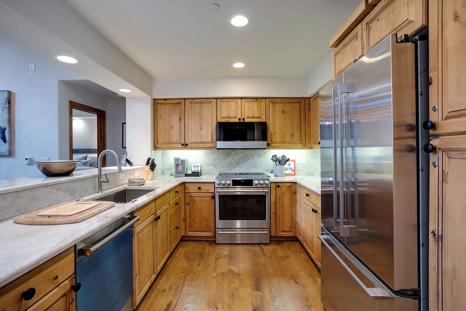 Your fully equipped kitchen features warm wood cabinetry, sleek stainless appliances, and plenty of counter space for preparing home-cooked meals during your stay.