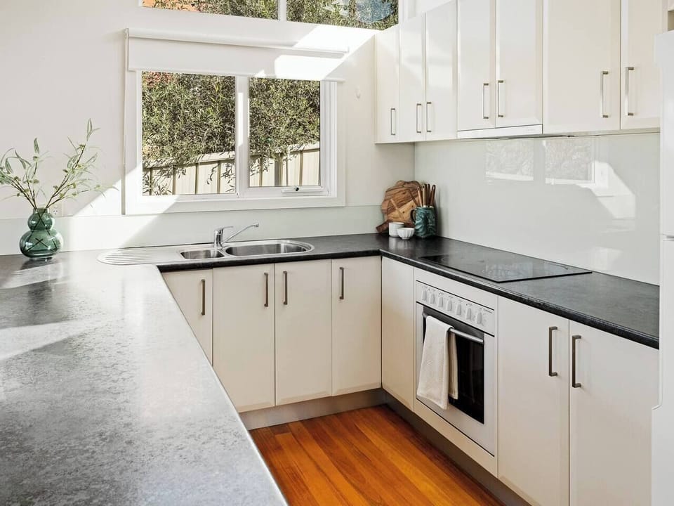 Prepare meals bathed in natural light and framed by leafy views, with every essential at your fingertips in this thoughtfully designed, cook-friendly kitchen.