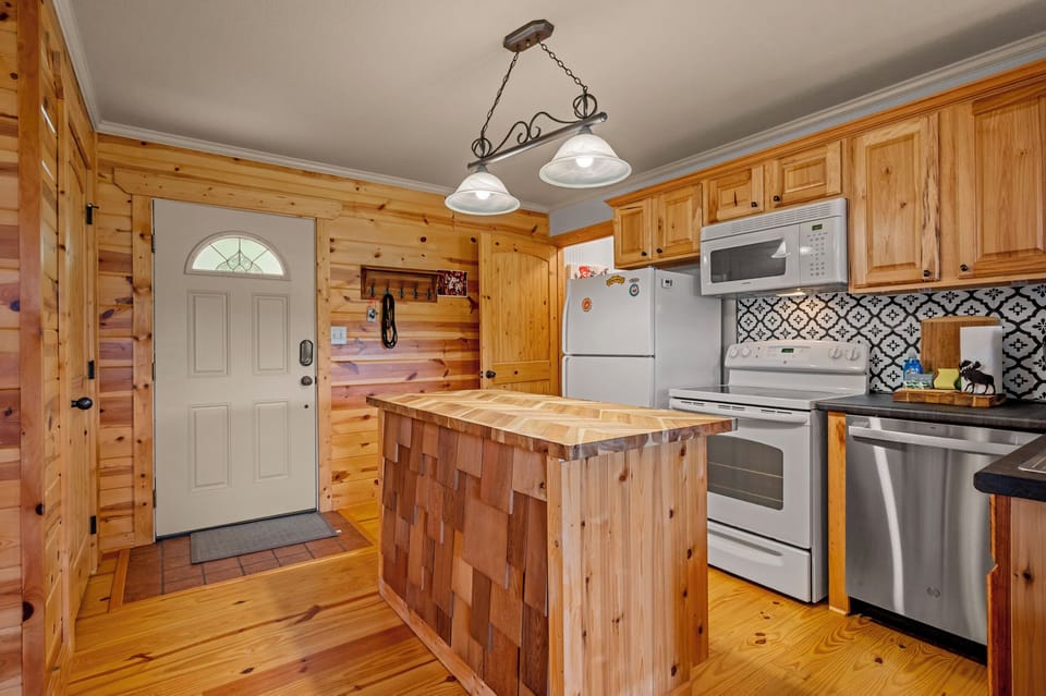 Kitchen view 1 (island, fridge, stove/oven, dishwasher, front door)
