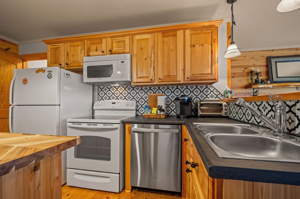 Kitchen view 3 (fridge, microwave, stove/oven, double sink)