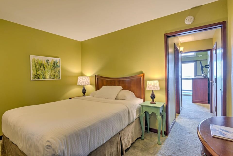 The cozy bedroom is highlighted by a comfortable queen bed, complemented by warm tones and soft lighting for a restful retreat.