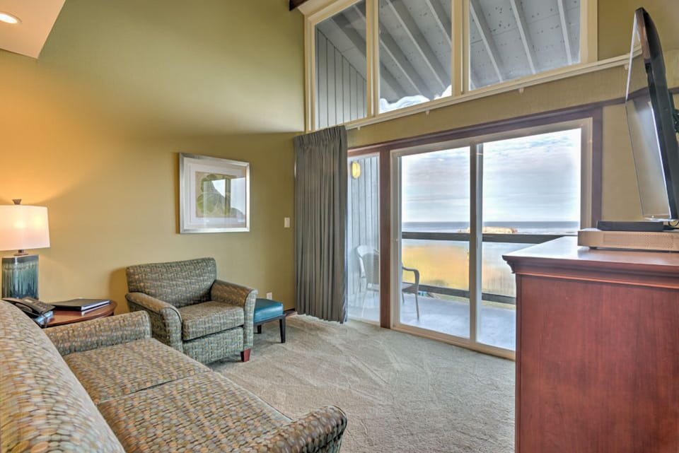 This bright sitting area showcases panoramic ocean views through expansive windows, with comfortable seating perfect for relaxation.