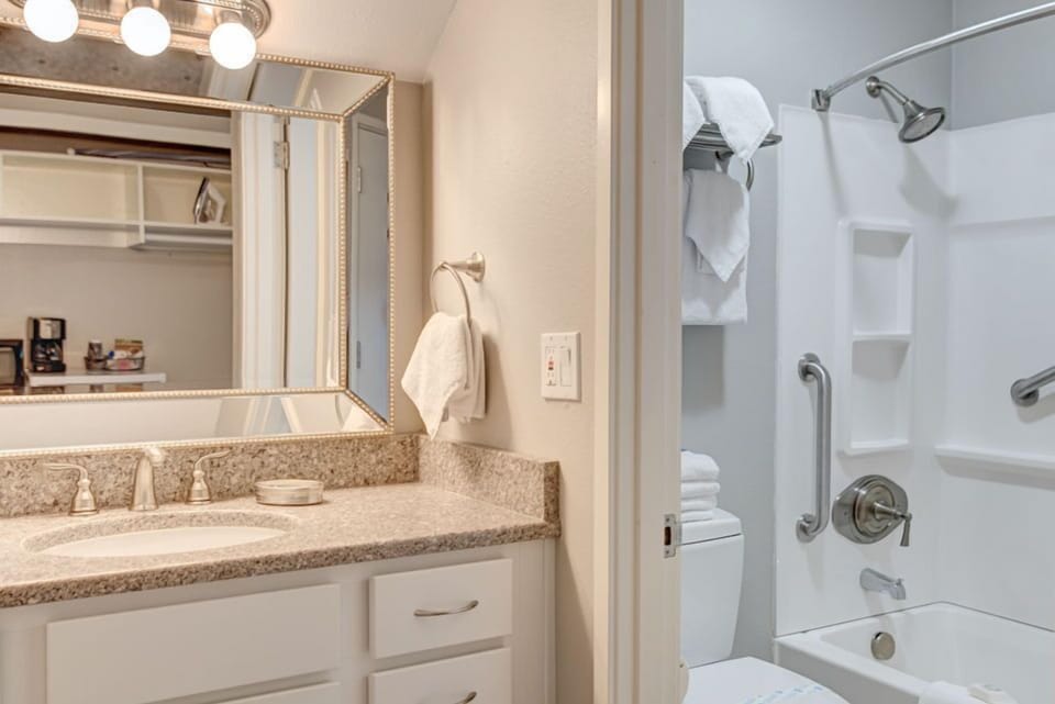 The modern bathroom is equipped with essential amenities, seamlessly integrating comfort and convenience in this Forest View 2 Queen Bedroom.