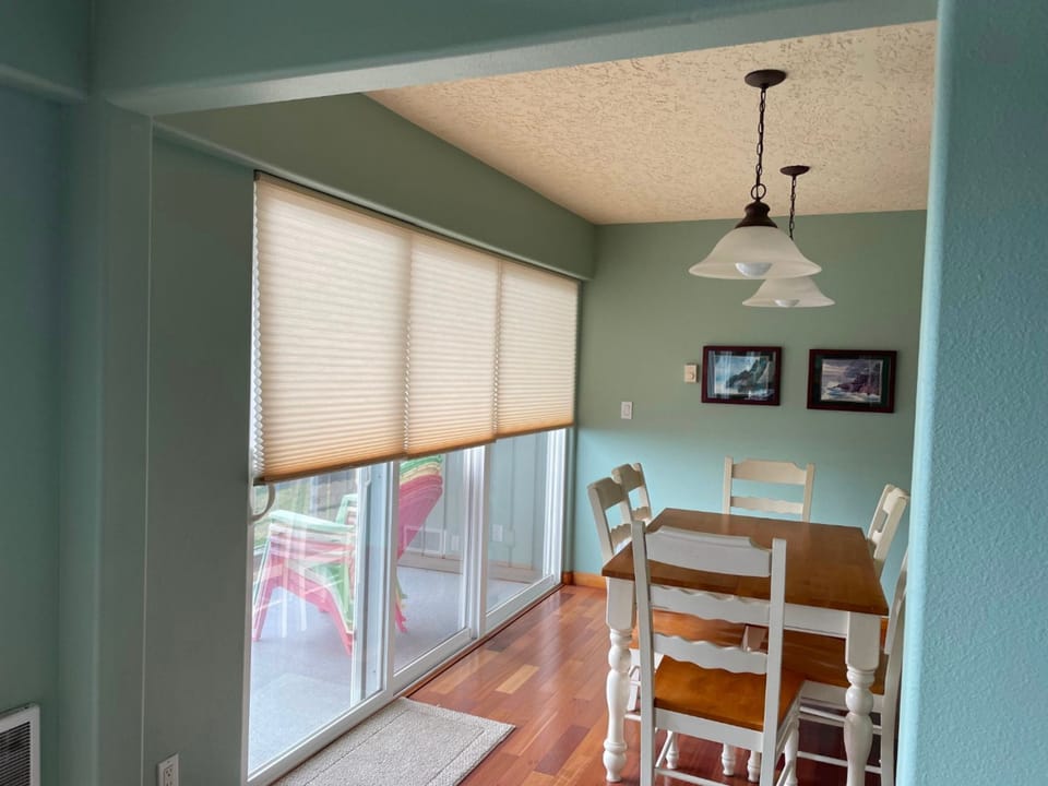 The inviting dining area, with its bright decor and large windows, offers a delightful space for family meals while enjoying ocean views.