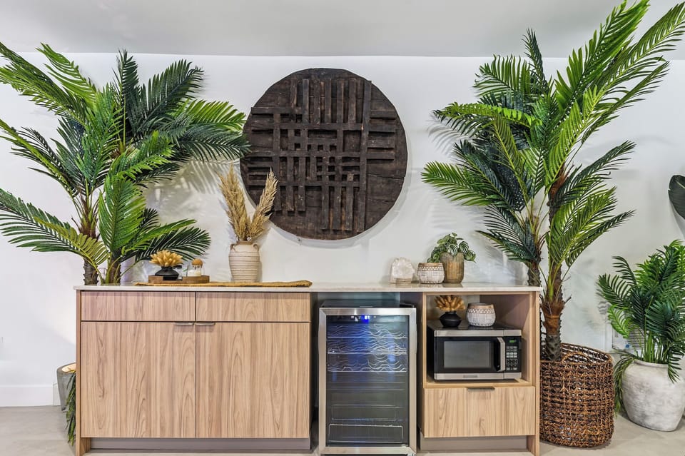 A hand-carved Mayan symbol from Tulum brings grounding energy to the Game Room, framed by natural quartzite, lush jungle plants, and a mini fridge + microwave. A signature TABU moment.