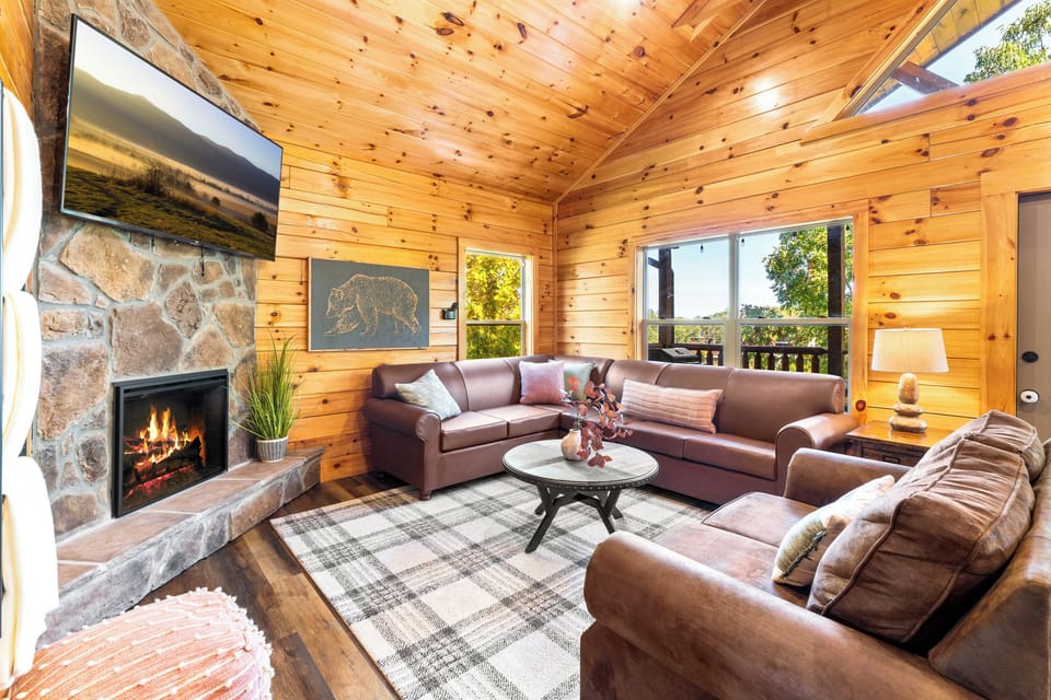 [Living Room] Electric fireplace, large smart HDTV with cable (Xfinity Stream). Queen sleeper sofa. No window coverings. Just outside is the first-floor deck with extra seating.