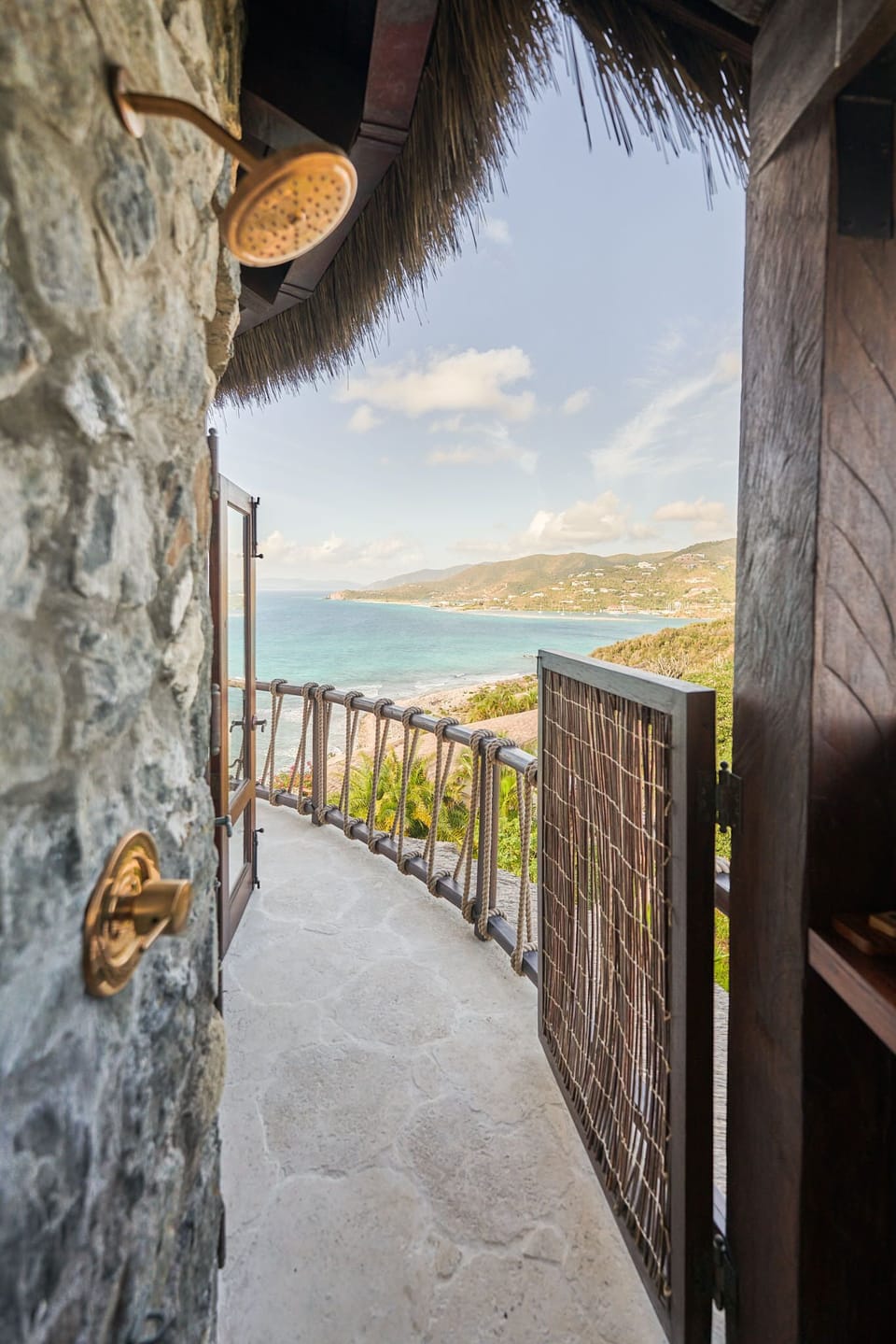 Step onto the outdoor shower with a view, surrounded by natural stone and offering panoramic vistas of the lush landscape and sparkling waters.