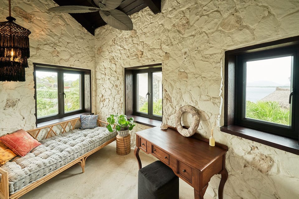 A cozy lounge area with textured stone walls and natural light—perfect for reading or relaxing.