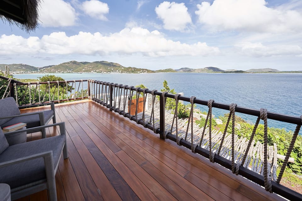 Expansive wooden deck with seating and panoramic bay views.