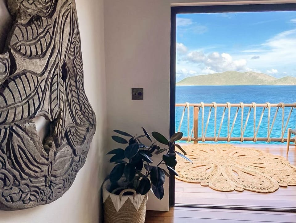 Stylish interior with carved wall art and direct access to ocean-view balcony.