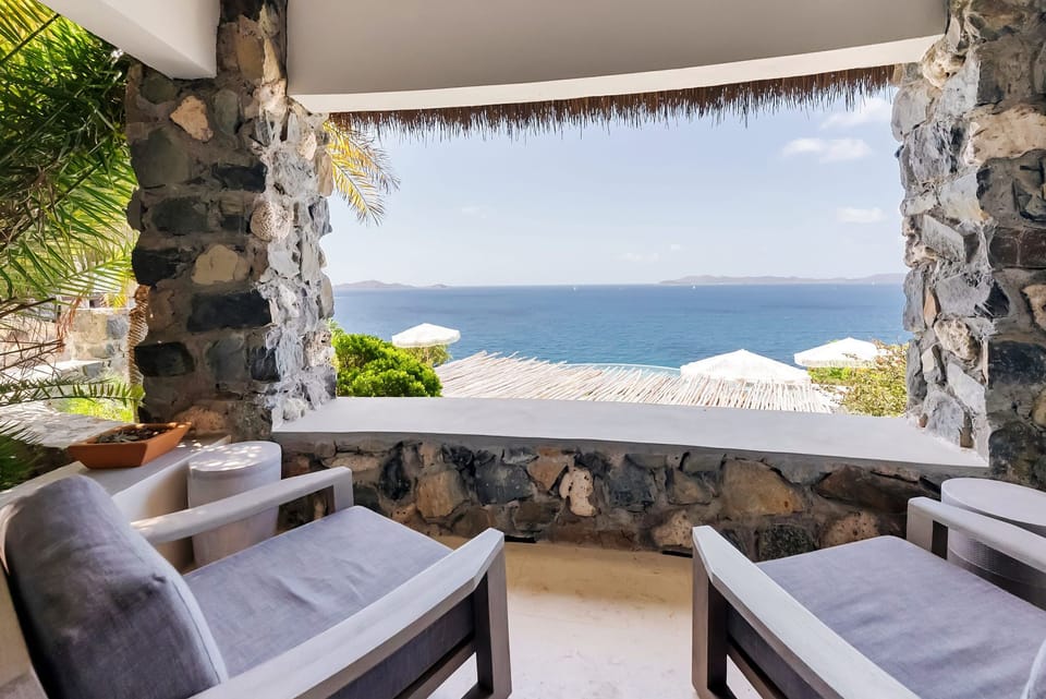 Covered stone deck with cozy lounge seating and sweeping views of the Caribbean Sea.