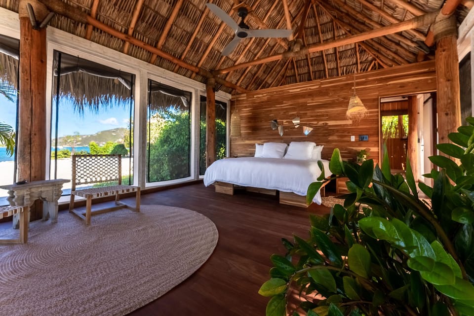 Rustic tropical suite with lush foliage, woven textures, and direct deck access.