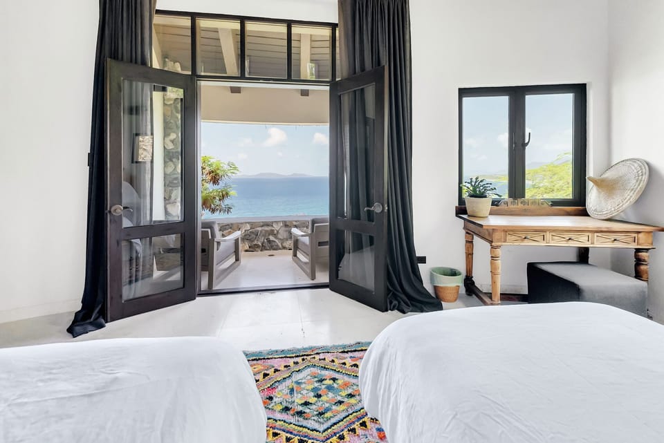 Spacious windows invite in natural light, illuminating the elegant interior and breathtaking island scenery.