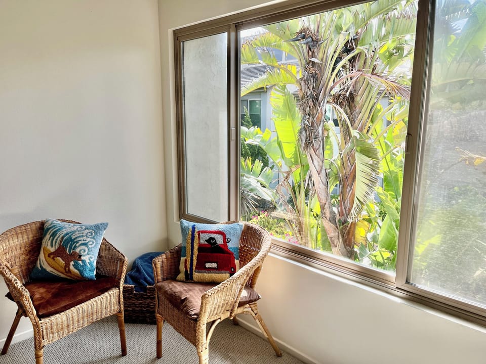 The plants outside the window makes it feel like a tropical treehouse