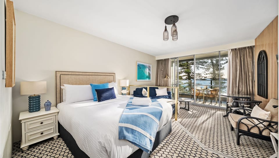 Light-filled bedroom retreat with plush bedding and balcony access.