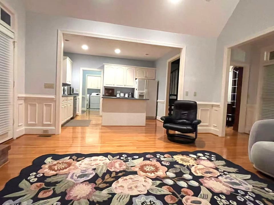 Open living area with kitchen view and floral accent rug