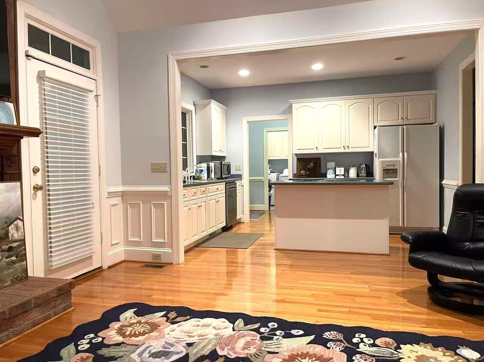 Open kitchen with white cabinetry and stainless-steel appliances