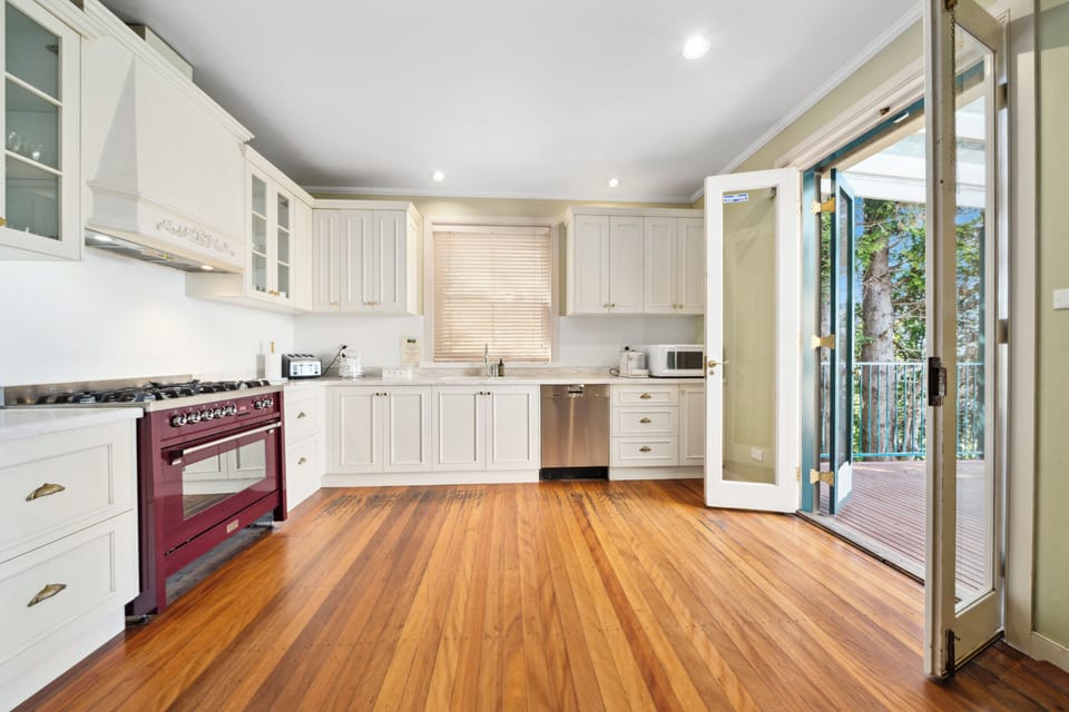 Kitchen with French doors opening to outdoor dining with point blank views