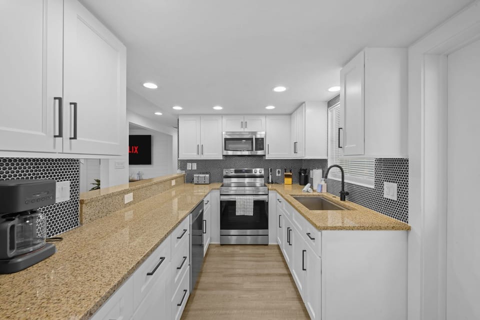 Our bright, clean kitchen with its stylish backsplash and new appliances is perfect for preparing meals with ease. It's the heart of the home, ready for you to enjoy.