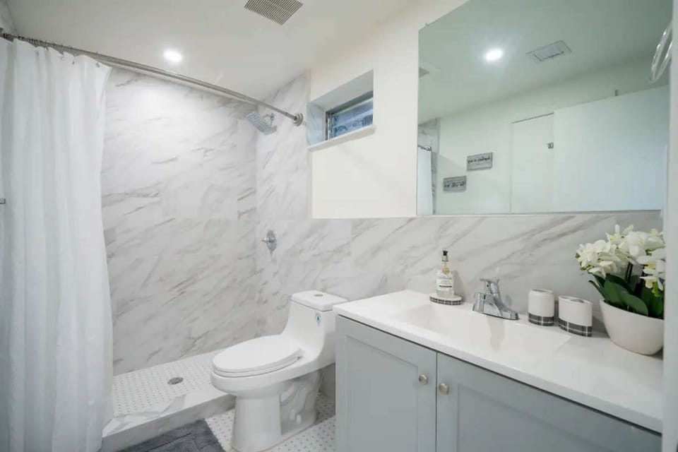 Bathroom with sink, toilet, shower, and large mirror