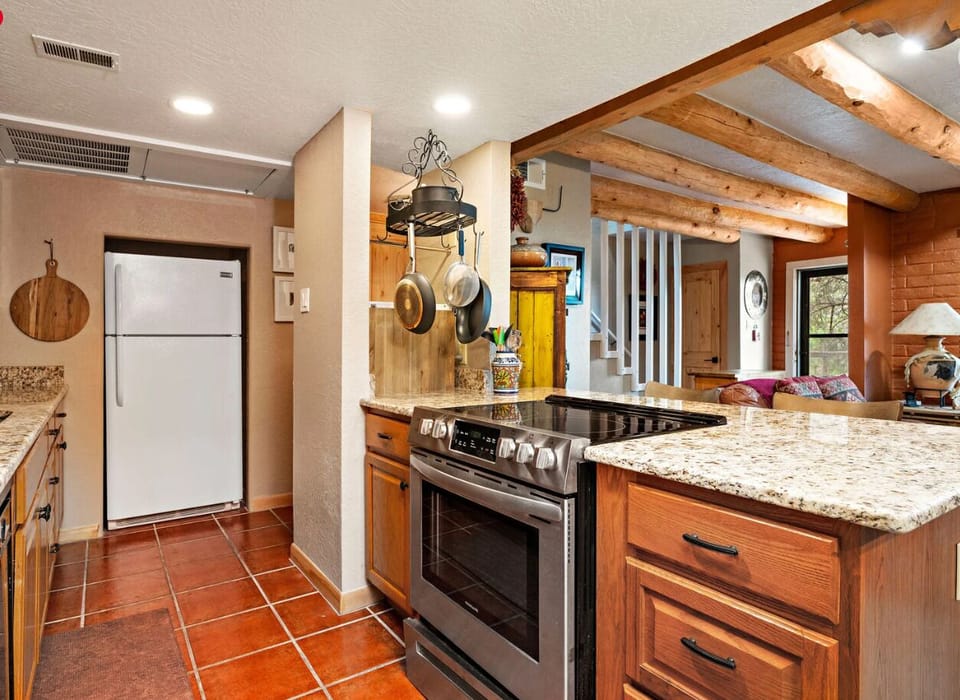 A full vista of the ground floor living space with a kitchen, half bath, living space, dining room and beautiful kiva.
