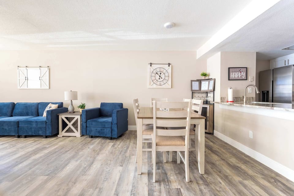 Open living and dining area with blue seating and modern kitchen appliances