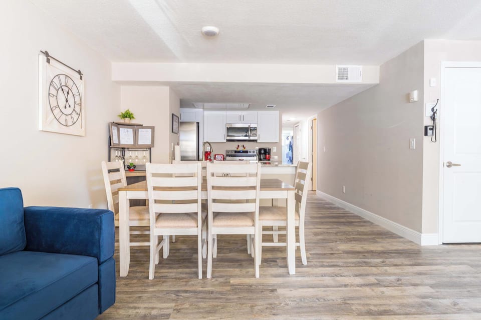 Open dining area with a view into the modern kitchen featuring stainless steel appliances.