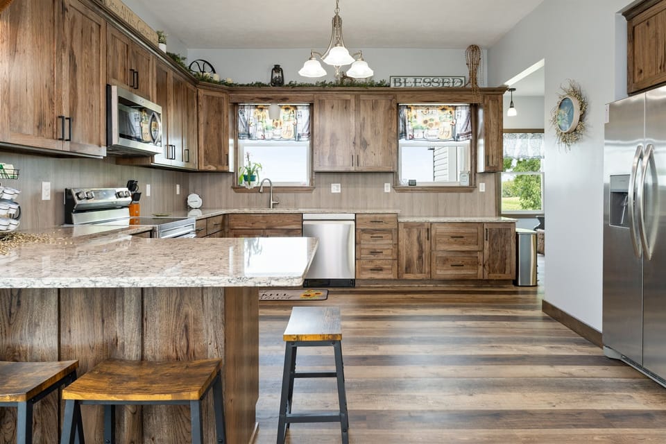 Expansive kitchen featuring stainless steel appliances, ample cabinet space, and plenty of natural light for a welcoming cooking experience.