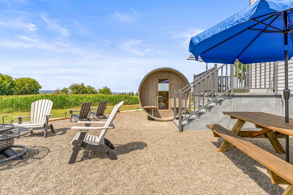 Cozy Adirondack chairs, picnic table, fire pit and a unique barrel sauna create the ultimate outdoor retreat.