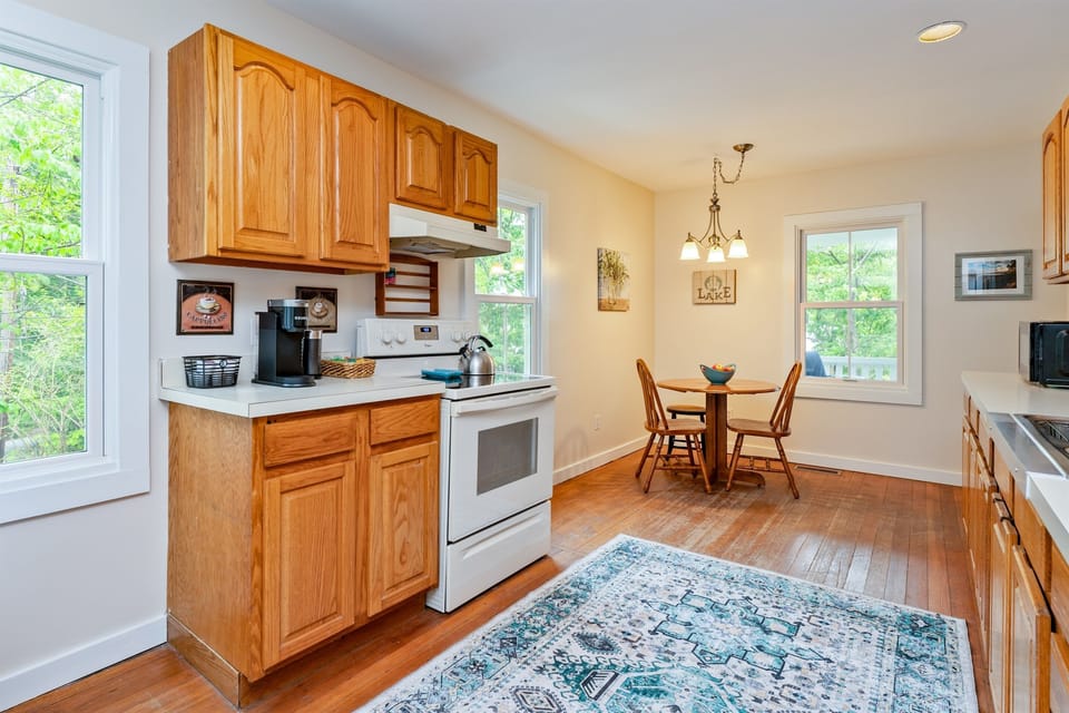 Bright and welcoming kitchen with warm wood cabinetry, modern appliances, and a cozy dining nook—perfect for morning coffee or casual meals.