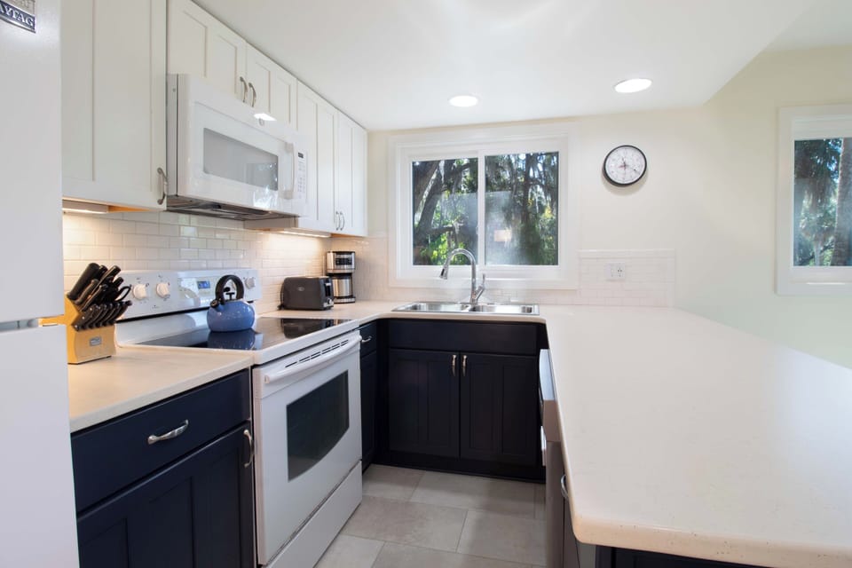 You'll love cooking in this bright, modern kitchen with everything you need—quality appliances, ample counter space, and peaceful garden views.