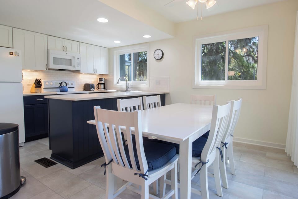 Your bright, modern kitchen awaits with sleek white cabinets and a spacious dining table where you'll enjoy morning coffee and evening meals together.