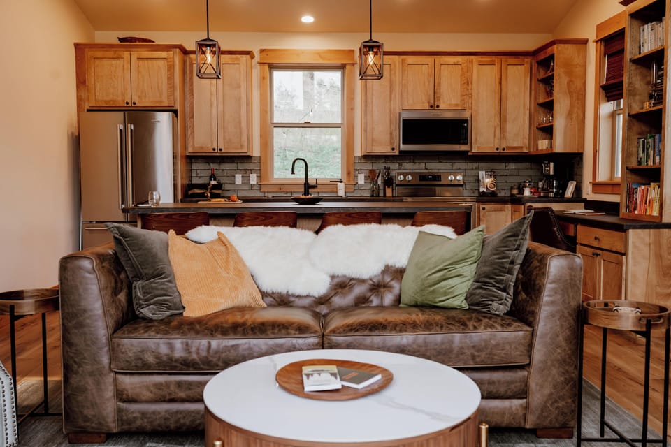 A deep leather couch in the living room: gaze out the window, watch a movie, or pull out the memory foam sleeper bed. 