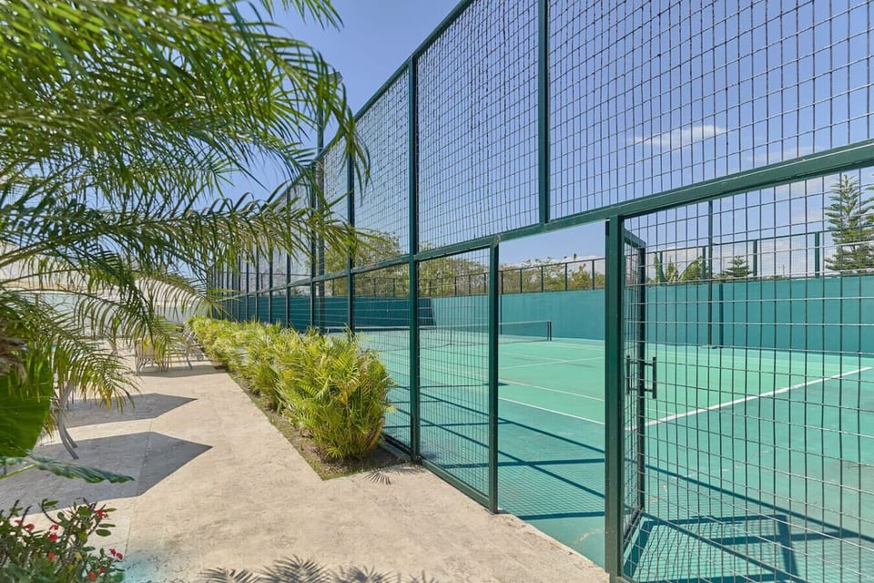 Entrada a la cancha de tenis frente a la piscina , para usar el equipo de tenis: raqueta y pelotas, el costo es de 15$ pregunta en el lobby