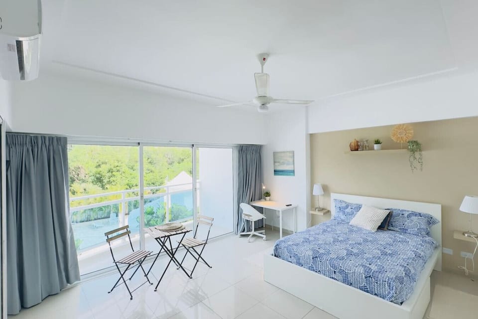 Habitación con aire acondicionado y ventilador colgante+ mesa para trabajar a un costado+pequeña mesa de pie con sillas para tomar alguna bebida,  excelente para tus vacaciones y trabajar, cuenta con balcon con vistas al exterior