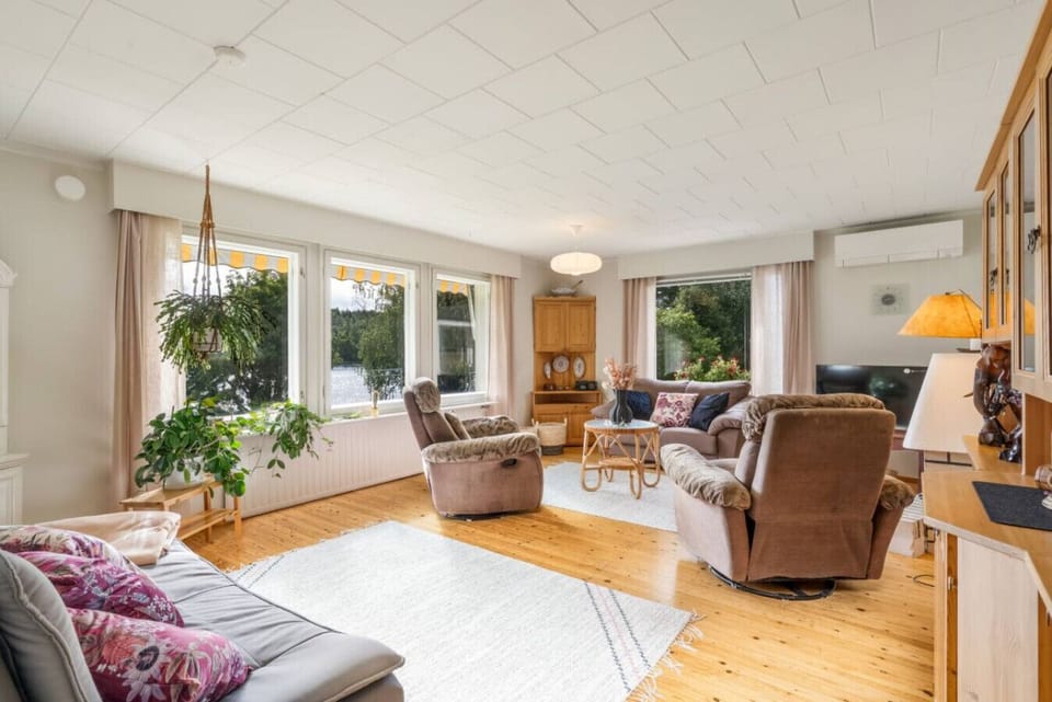 A welcoming space to relax and unwind, featuring plush seating, large windows with views of nature and the river, and plenty of natural light.