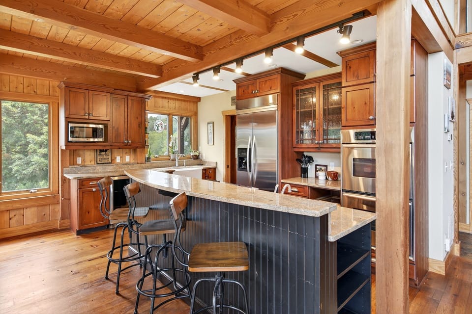 Well-equipped kitchen with gas range, drip-style coffee maker, dining area for 8, and island seating for 3