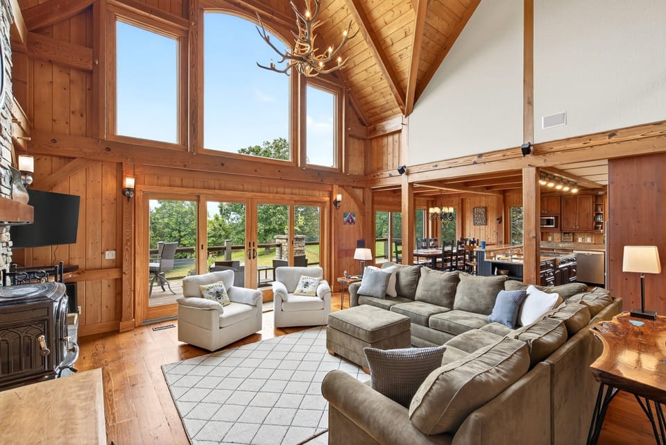 Living room with spacious sectional, TV for streaming, wood stove, and access to the deck